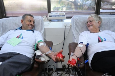 Palestinian Wajee Tameise and Israeli Mashka Litvak donate blood together as part of the "Blood Relations" project.